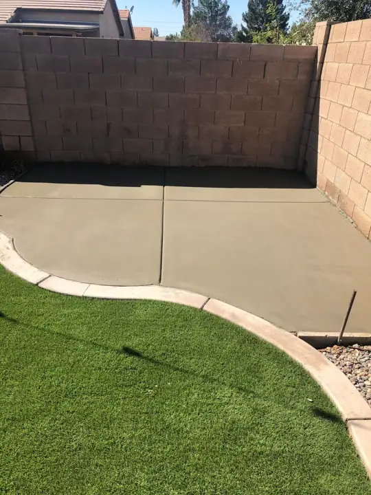 Curved patio with turf border in Chandler, AZ, poured by Gaitan Custom Concrete